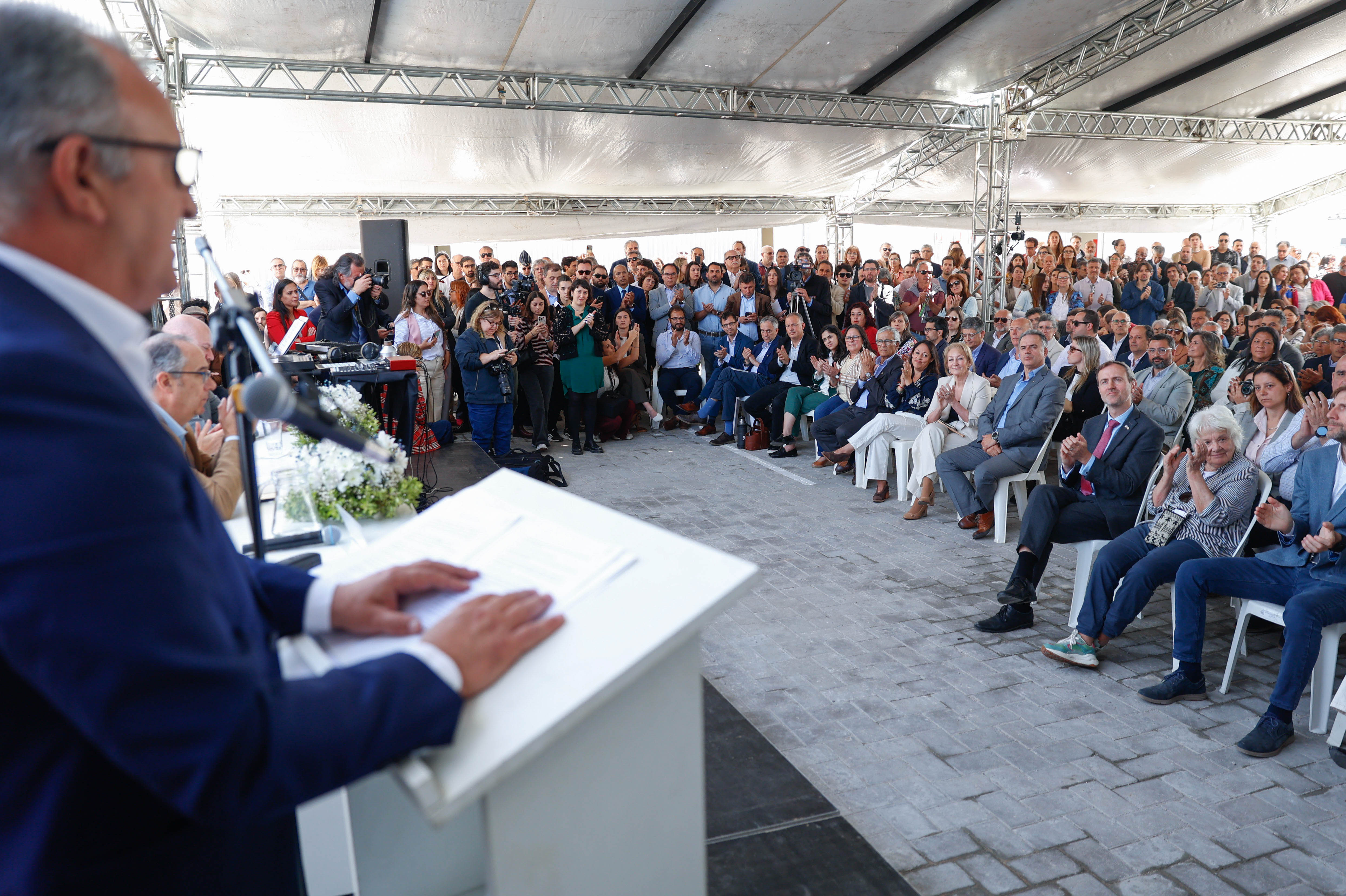 Intendente de Lavalleja dando un discurso desde un atril a una gran audiencia reunida bajo una carpa en el evento.