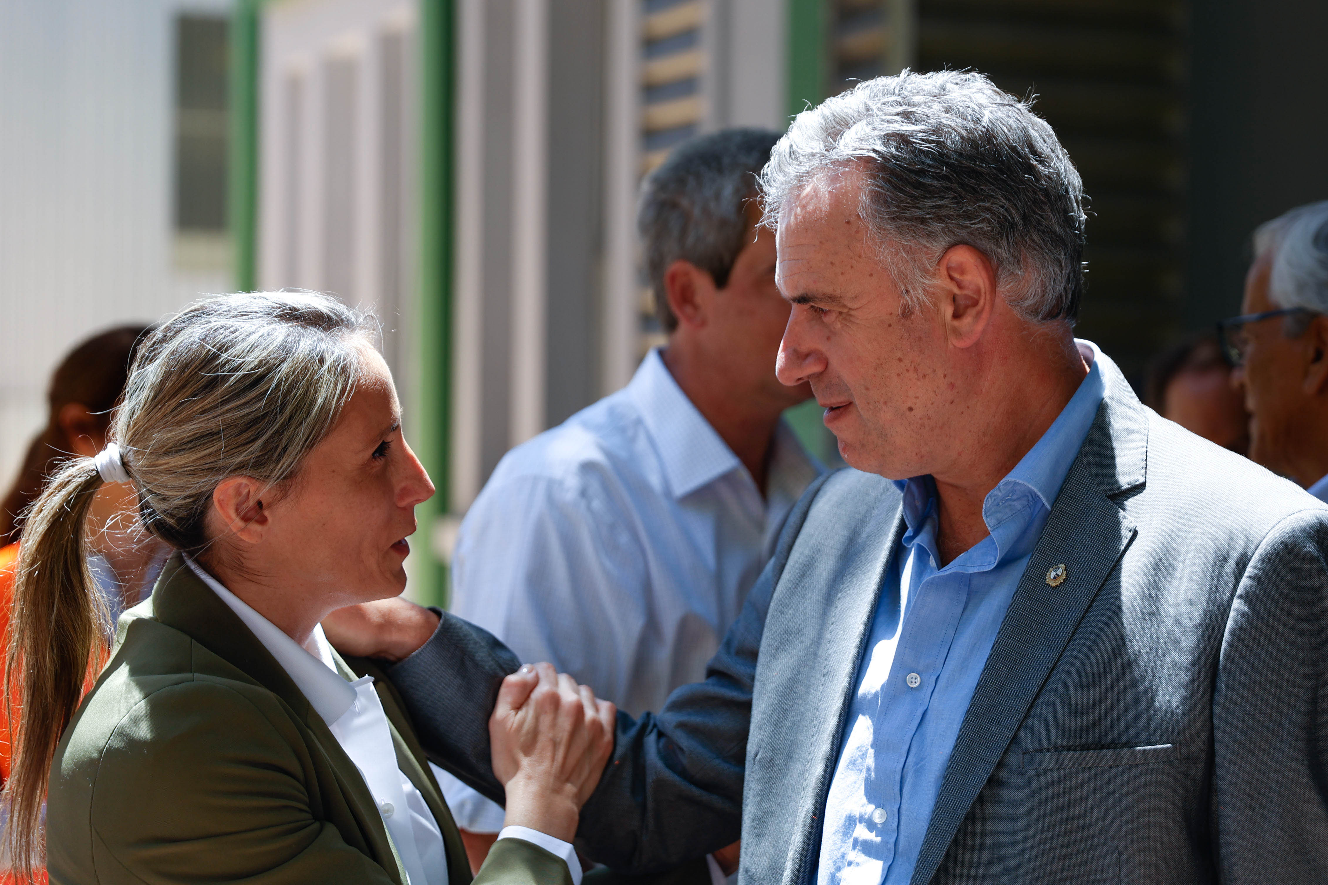 Orsi saluda con un abrazo a una directiva de la empresa Salus en el ingreso a la reserva. Atrás se observan otras personas interactuando.