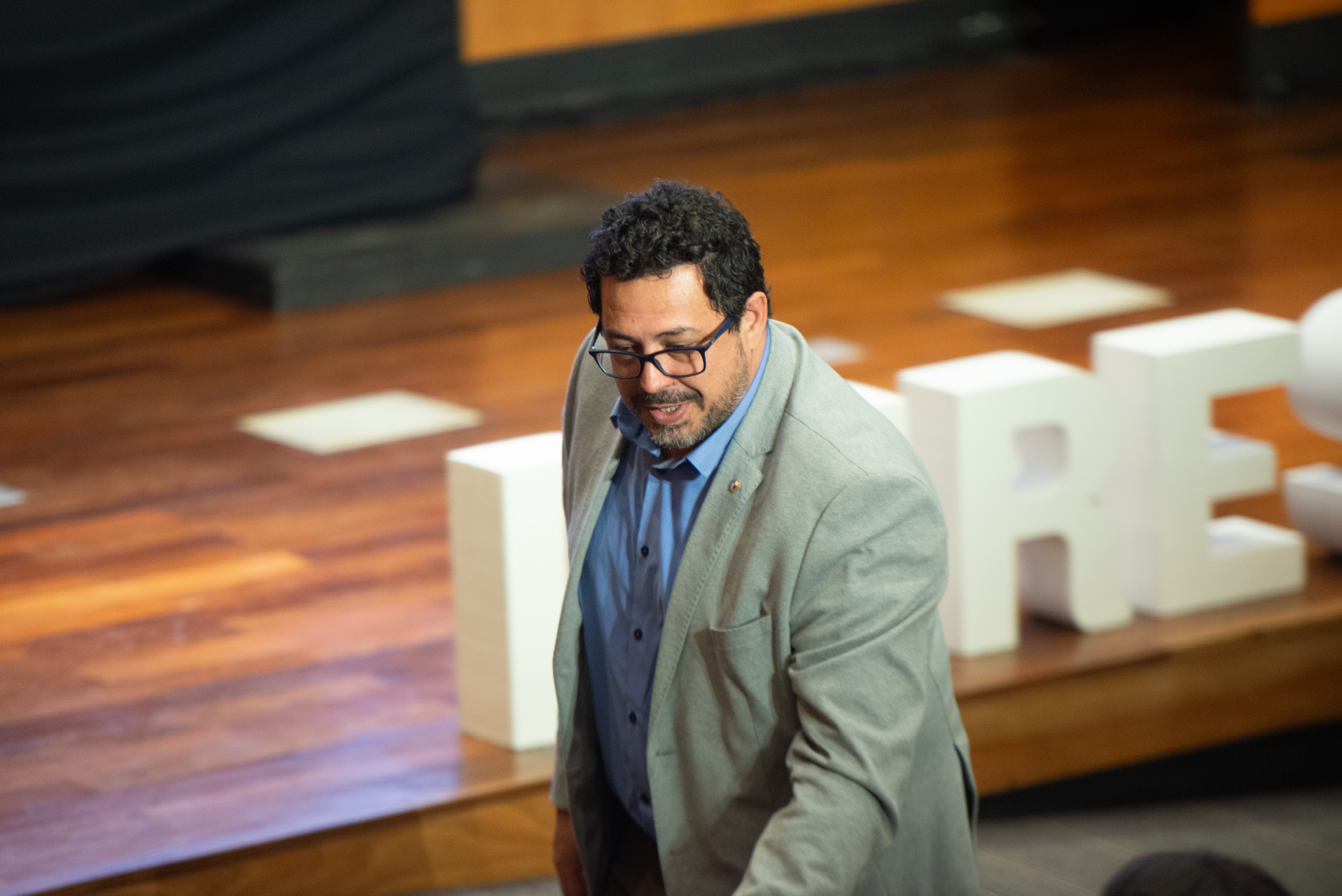 Secretario de Presidencia de pie en la platea del auditorio.