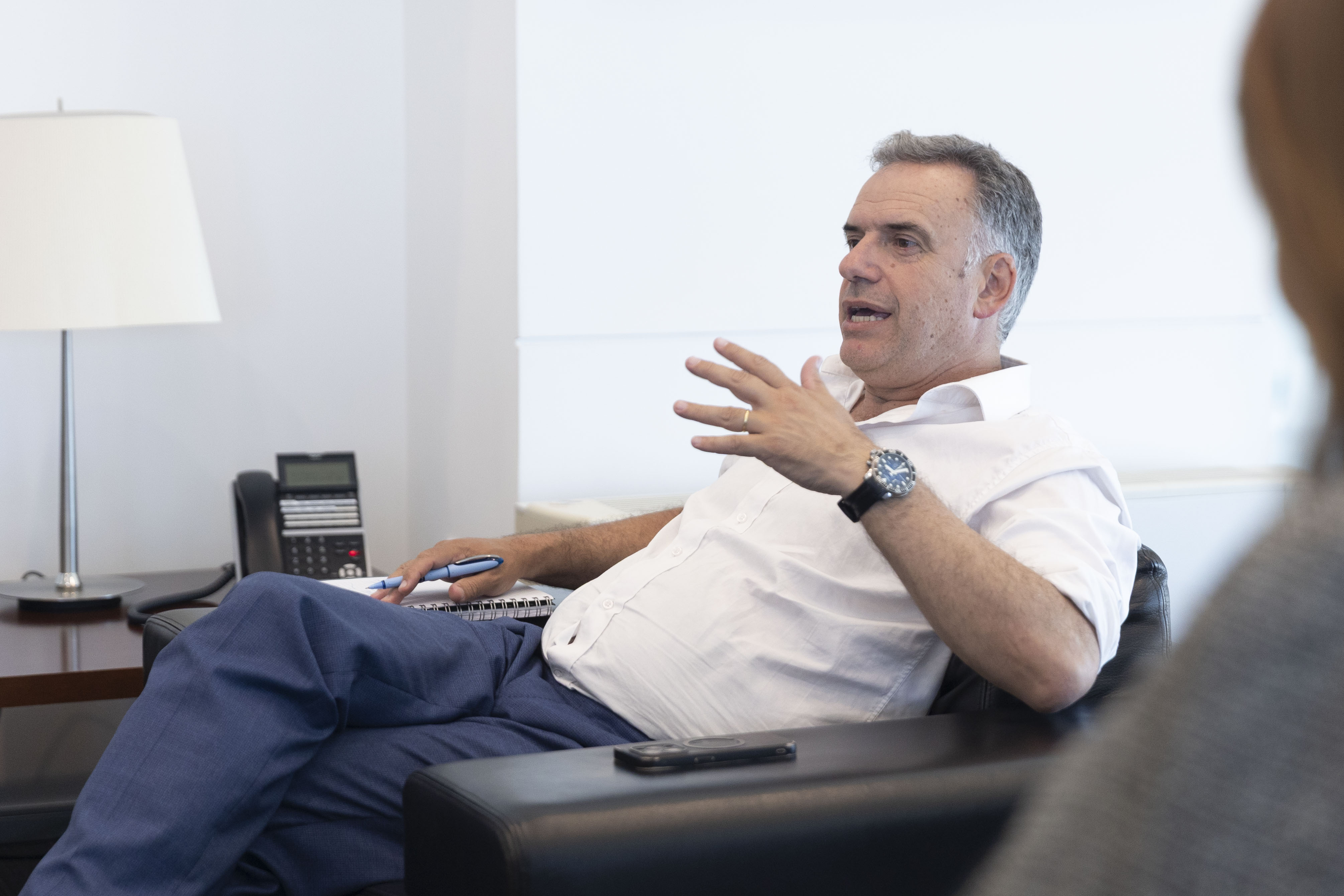 Primer plano de Orsi gesticulando mientras conversa sentado en un sillón de la sala de reuniones de Presidencia.