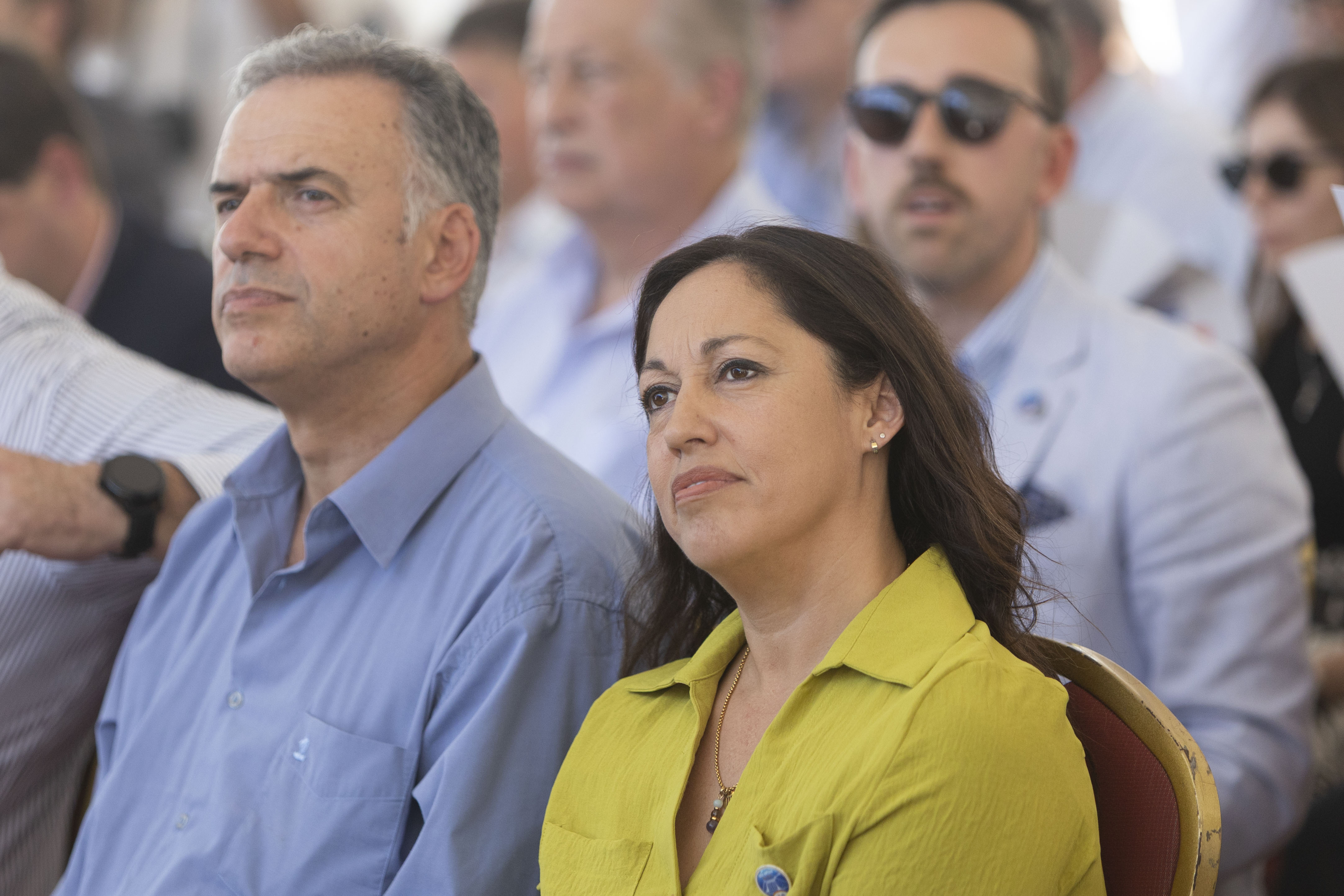 Orsi y la ministra de Industria sentados en primera fila de la platea escuchan atentamente una disertación.