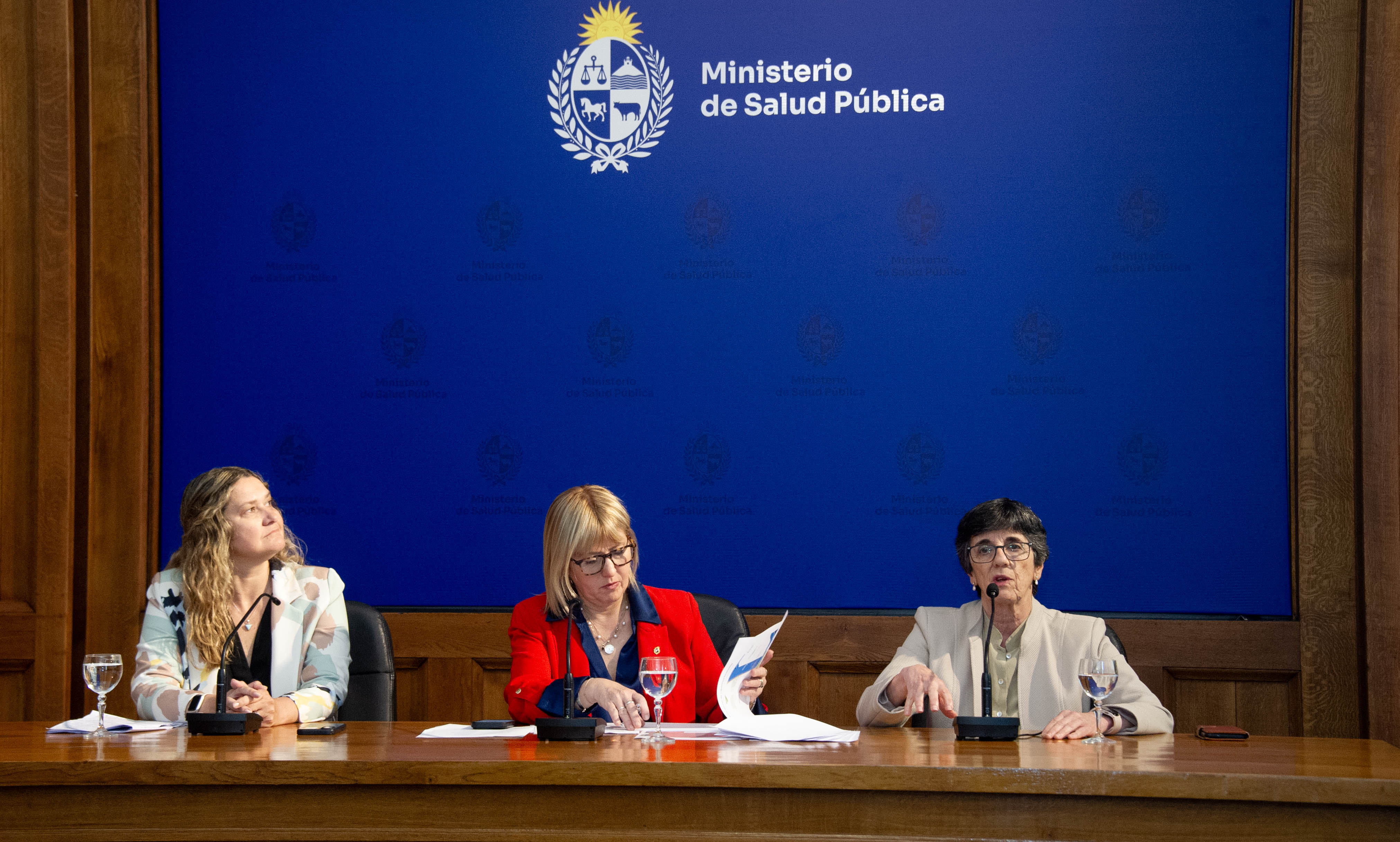 Presidenta del Fondo Nacional de Recursos diserta sentada en mesa con micrófono junto a las otras autoridades.